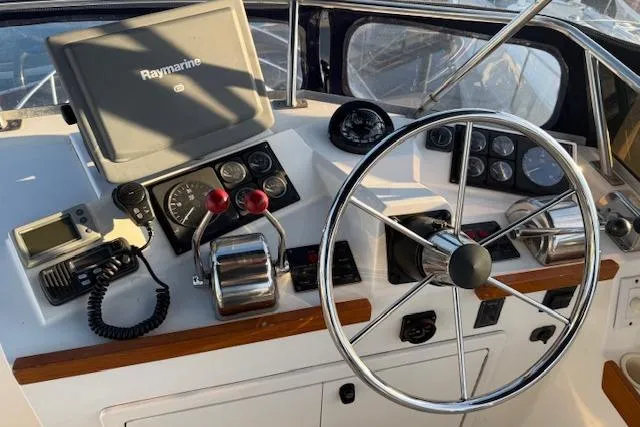 Ocean Baron Yacht Photos Pics 2001 Sabreline Sedan helm with steering wheel, navigation equipment, and control panel.