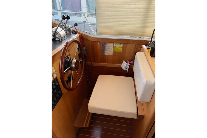 Ocean Baron Yacht Photos Pics 2001 Sabreline Sedan helm with wooden steering wheel and cushioned seat.