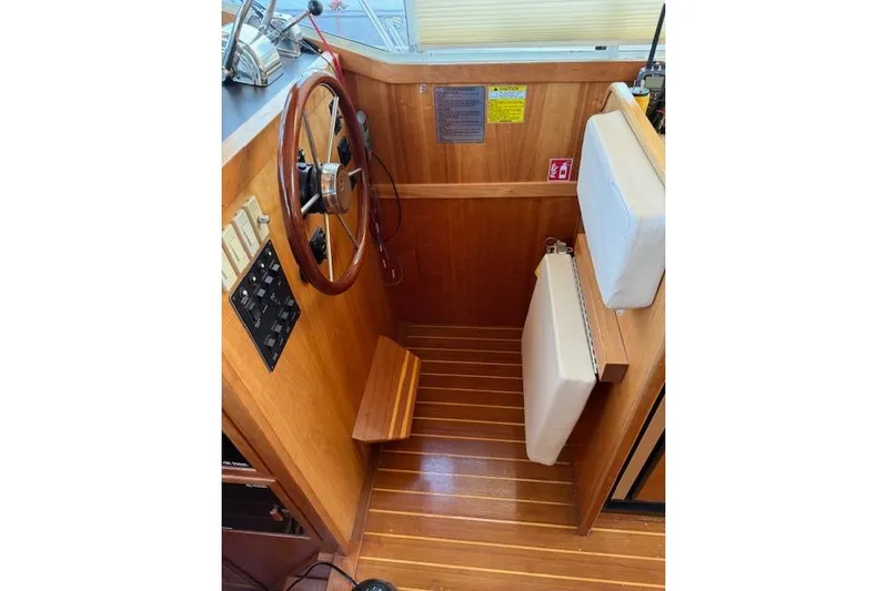 Ocean Baron Yacht Photos Pics 2001 Sabreline Sedan helm with wooden steering wheel and cushioned seat.