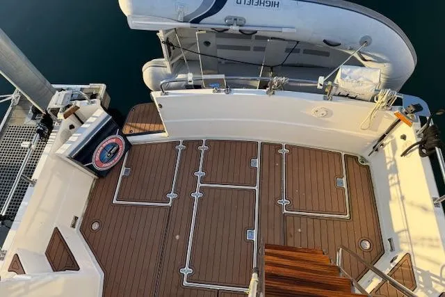 Ocean Baron Yacht Photos Pics 2001 Sabreline Sedan boat deck with wooden flooring and attached dinghy.