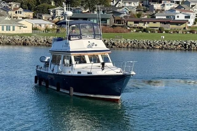 Ocean Baron Yacht Photos Pics 2001 Sabreline Sedan boat cruising in a scenic coastal area.