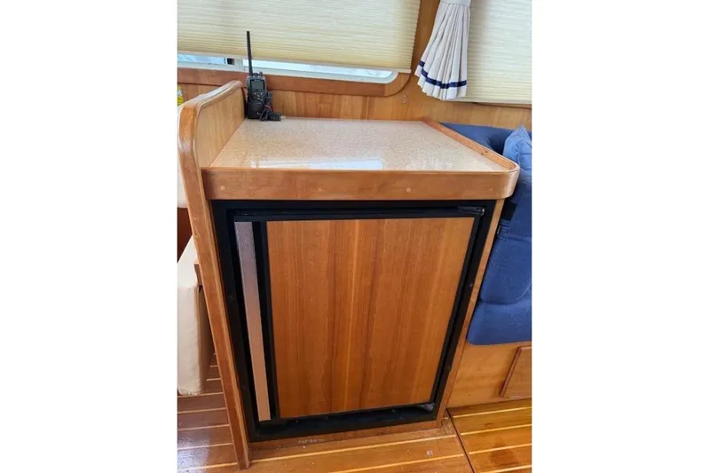 Ocean Baron Yacht Photos Pics 2001 Sabreline Sedan interior with wooden cabinetry and compact fridge.
