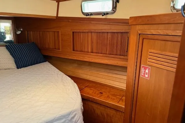 Ocean Baron Yacht Photos Pics 2001 Sabreline Sedan interior with wooden cabinetry and cozy bed.