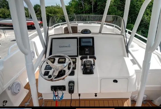  Yacht Photos Pics 2008 Intrepid 370 Cuddy helm with Garmin navigation, steering wheel, and controls, surrounded by lush greenery.