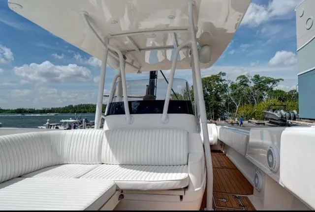  Yacht Photos Pics 2008 Intrepid 370 Cuddy boat with white seating and wooden deck, docked by the water.
