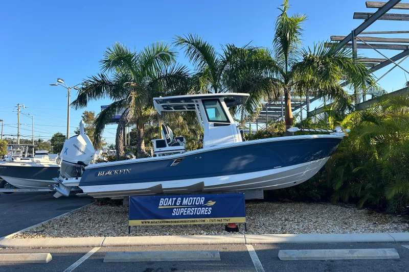  Yacht Photos Pics 2026 Blackfin 242 HB boat displayed at dealership, surrounded by palm trees.