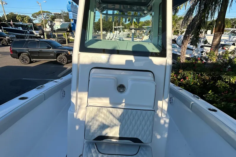  Yacht Photos Pics 2026 Blackfin 242 HB boat interior with seating and console, parked near vehicles and greenery.