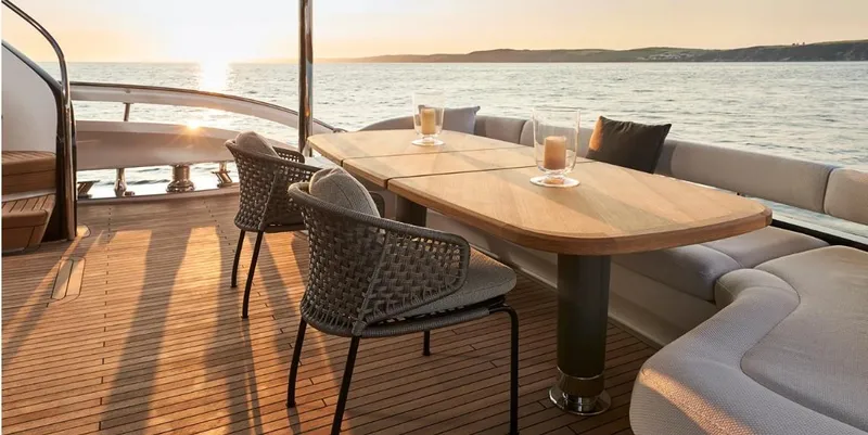  Yacht Photos Pics Luxurious 2026 Princess X95 Vista yacht deck with elegant seating and ocean view at sunset.