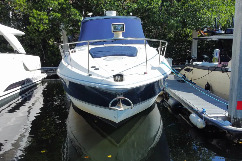  Yacht Photos Pics 2007 Cruisers Yachts 370 Express docked, surrounded by lush greenery.