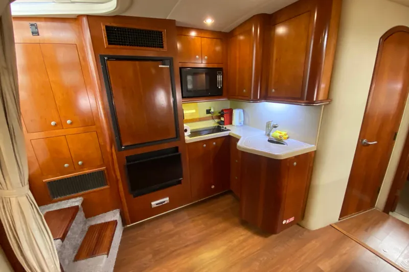  Yacht Photos Pics 2007 Cruisers Yachts 370 Express interior kitchen with wood cabinetry and modern appliances.