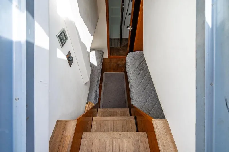  Yacht Photos Pics Interior staircase of 2010 Princess V78 yacht with wooden steps and cushioned walls.