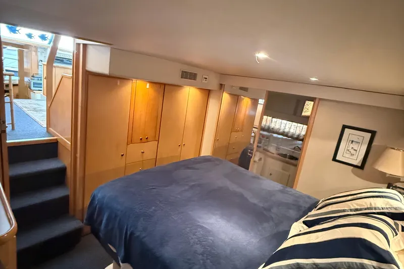 Chardonnay Yacht Photos Pics 1998 Carver 440 Aft Cabin Motor Yacht interior with cozy bedroom and wooden cabinetry.