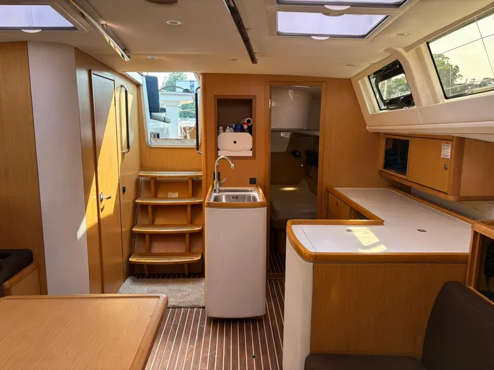 Hallucination Yacht Photos Pics Interior of 2012 Bavaria Vision 46 yacht with modern wood finish and compact kitchen.
