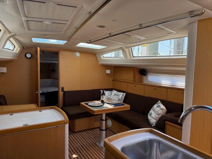 Hallucination Yacht Photos Pics Interior of 2012 Bavaria Vision 46 yacht with cozy seating and dining area.