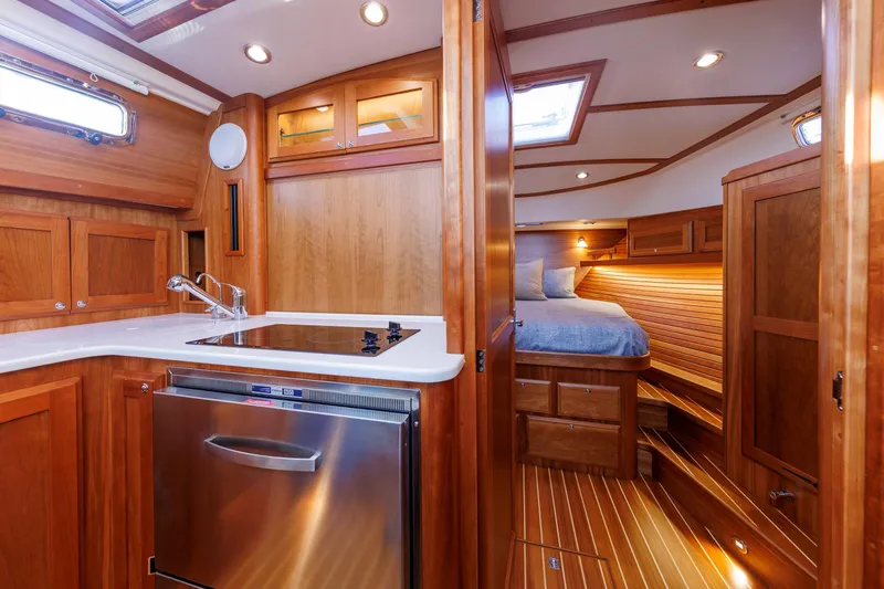  Yacht Photos Pics Interior of 2022 Sabre 38 SE yacht featuring kitchen and cozy bedroom.