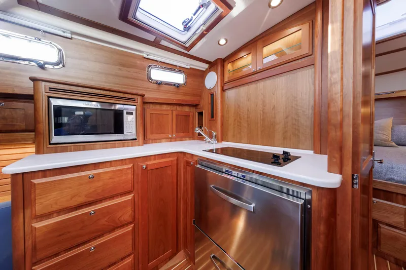  Yacht Photos Pics Luxurious 2022 Sabre 38 SE yacht kitchen with wood cabinetry and modern appliances.