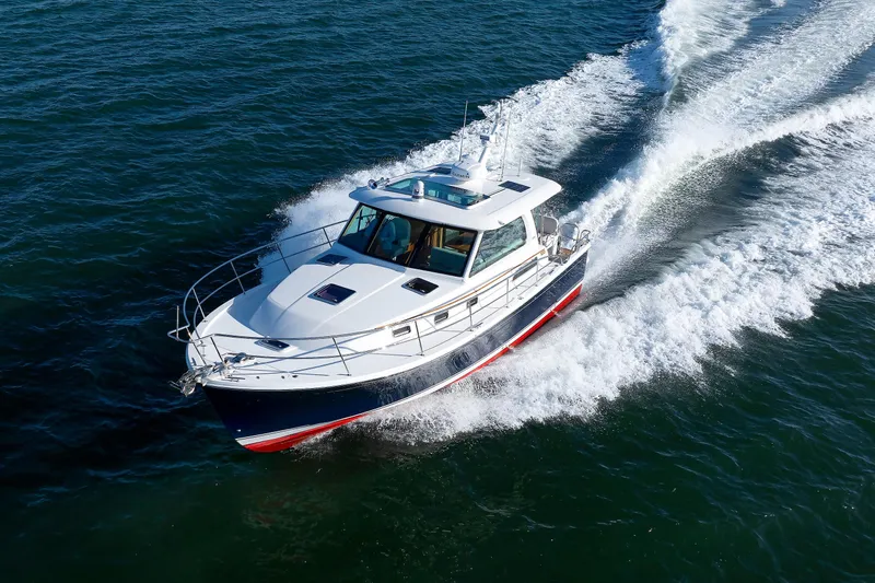  Yacht Photos Pics 2022 Sabre 38 SE yacht cruising on open water, creating a dynamic wake.