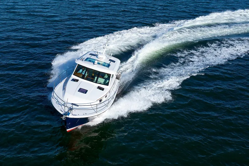  Yacht Photos Pics 2022 Sabre 38 SE yacht cruising on open water, creating a dynamic wake.