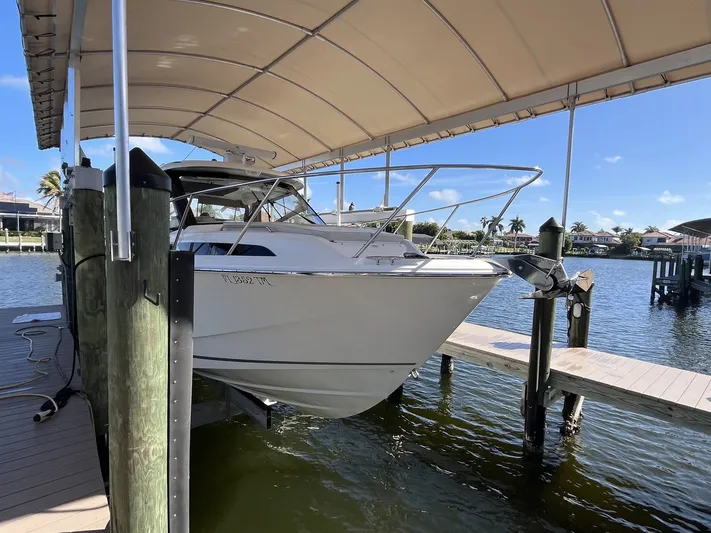  Yacht Photos Pics 2023 Boston Whaler 325 Conquest on a covered boat lift.