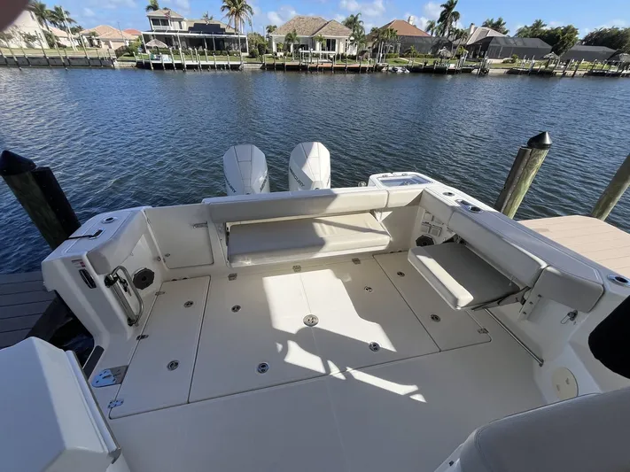  Yacht Photos Pics Boston Whaler 325 Conquest 2023 by the water with luxurious deck.