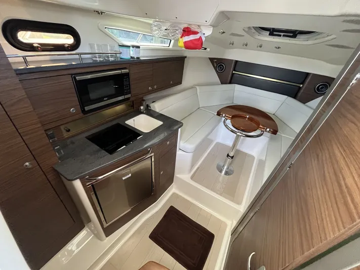  Yacht Photos Pics Interior of 2023 Boston Whaler 325 Conquest yacht with kitchen and seating area.