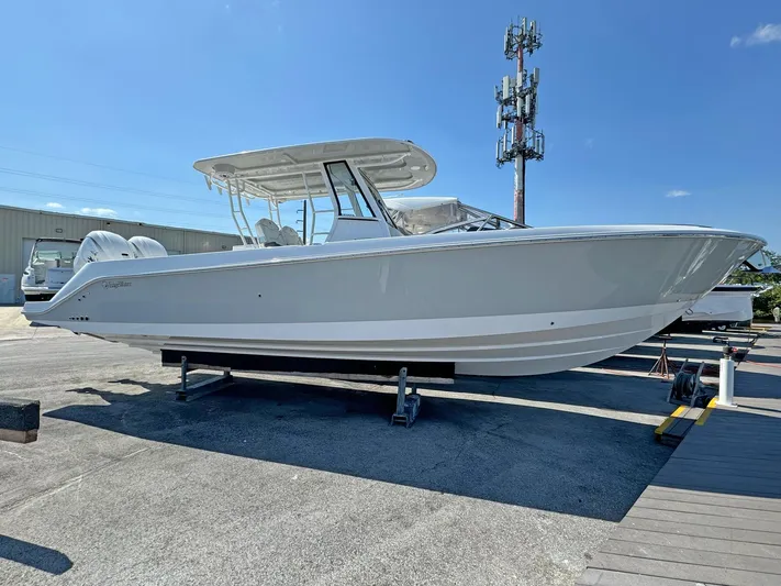  Yacht Photos Pics 2025 Edgewater 340CC boat on display, sleek design, clear blue sky background.