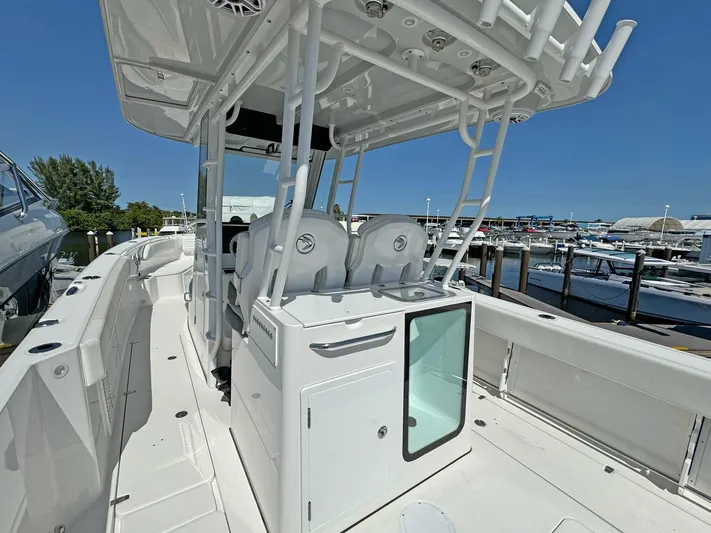 Yacht Photos Pics 2025 Edgewater 340CC boat interior at marina, showcasing seating and storage features.