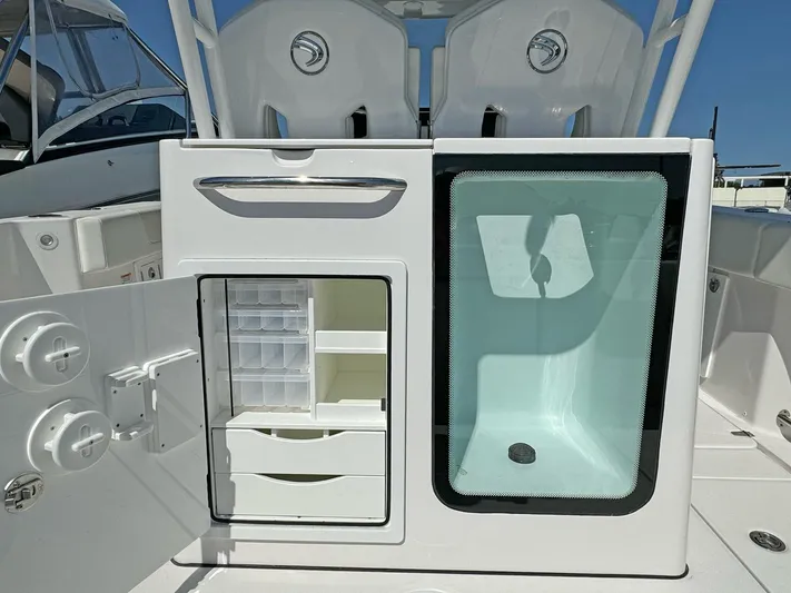  Yacht Photos Pics 2025 Edgewater 340CC boat storage compartments with open door and transparent panel.