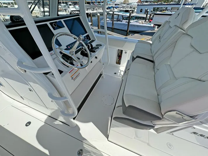  Yacht Photos Pics 2025 Edgewater 340CC boat interior with steering wheel and seating at marina.