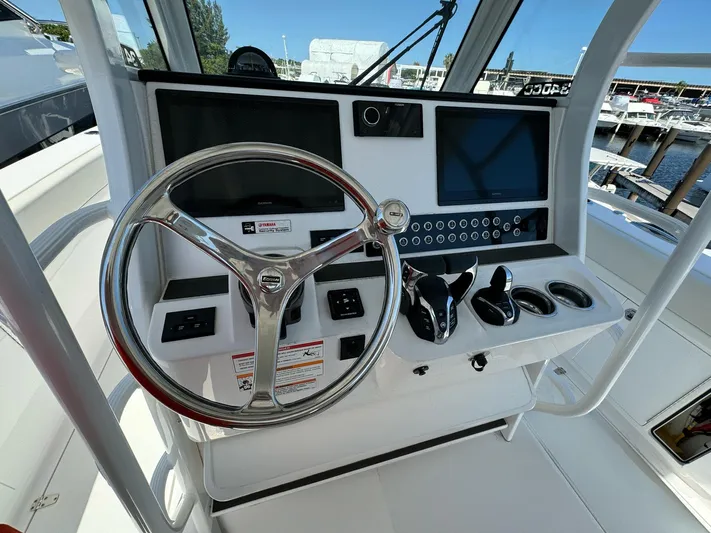  Yacht Photos Pics Edgewater 340CC 2025 boat helm with steering wheel, dual screens, and control panel.