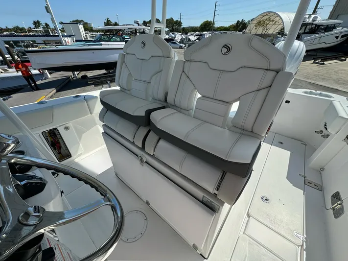  Yacht Photos Pics 2025 Edgewater 340CC boat interior with dual white cushioned seats and steering wheel.