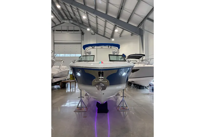  Yacht Photos Pics 2026 Regal LS6 Surf boat displayed in a showroom with sleek design and blue accents.