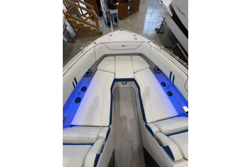  Yacht Photos Pics 2026 Regal LS6 Surf boat interior with white and blue seating, ambient lighting.