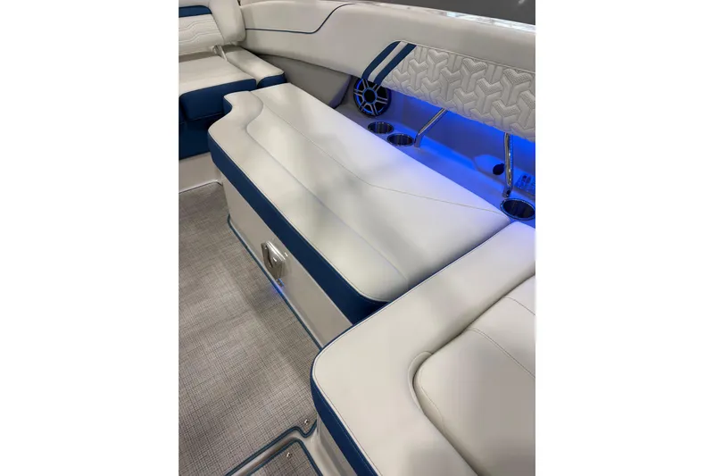  Yacht Photos Pics 2026 Regal LS6 Surf boat interior with white and blue seating, ambient lighting.