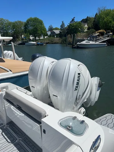  Yacht Photos Pics Edgewater 340CC 2021 boat with twin Yamaha outboard engines docked by a serene waterfront.