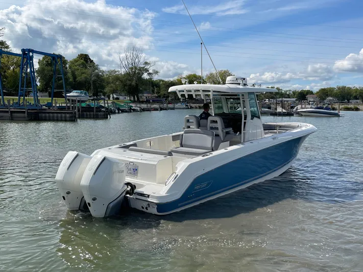  Yacht Photos Pics 2022 Boston Whaler 330 Outrage boat on calm water, featuring twin engines.