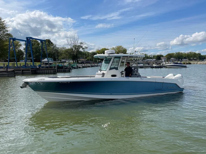  Yacht Photos Pics 2022 Boston Whaler 330 Outrage boat on calm water under a blue sky.
