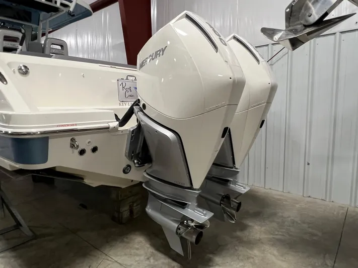  Yacht Photos Pics 2022 Boston Whaler 330 Outrage with dual Mercury outboard engines in a garage setting.