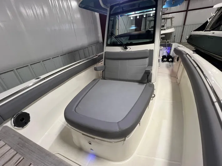  Yacht Photos Pics 2022 Boston Whaler 330 Outrage boat interior with gray seating in a showroom.