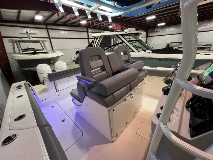  Yacht Photos Pics 2022 Boston Whaler 330 Outrage interior with plush seating and modern design in a showroom.