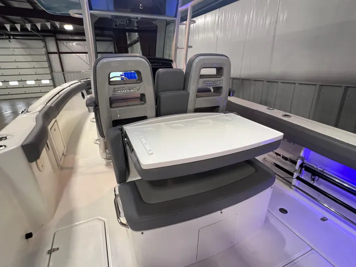  Yacht Photos Pics 2022 Boston Whaler 330 Outrage boat interior with seating and table.