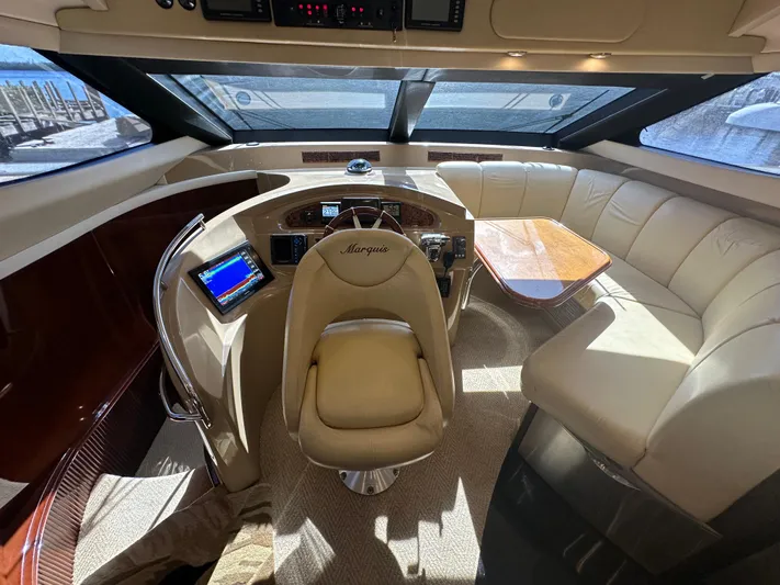 La Vida Loca Yacht Photos Pics Luxurious 2004 Marquis 59 yacht interior with leather seating and modern helm.