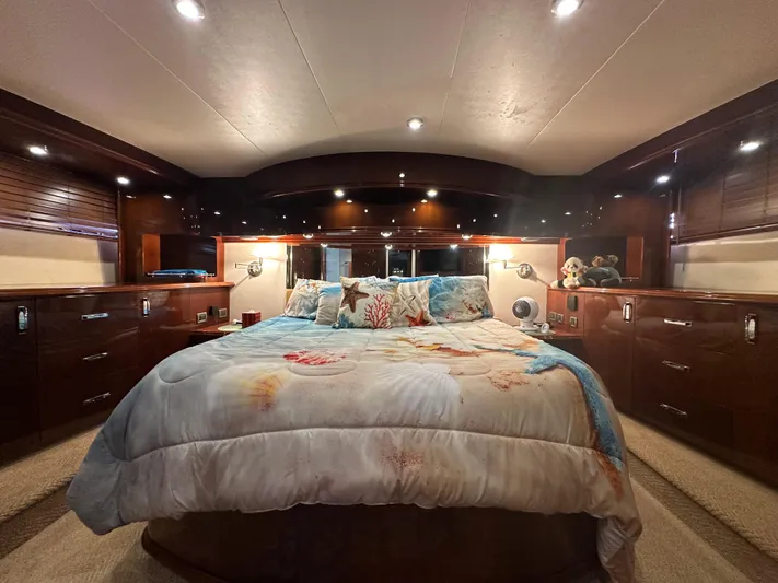 La Vida Loca Yacht Photos Pics Luxurious bedroom interior of 2004 Marquis 59 yacht with elegant wood finishes.