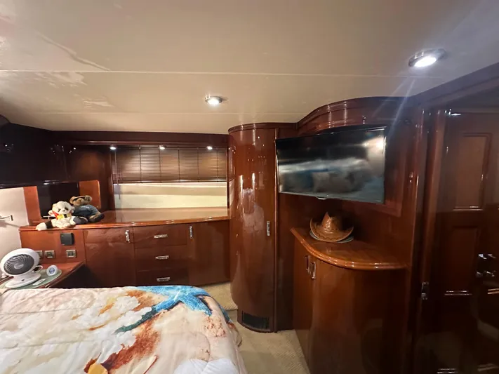 La Vida Loca Yacht Photos Pics Luxurious 2004 Marquis 59 yacht bedroom with wood cabinetry and modern amenities.