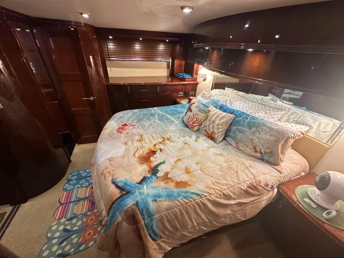 La Vida Loca Yacht Photos Pics Luxurious 2004 Marquis 59 yacht bedroom with ocean-themed bedding and elegant wood finishes.