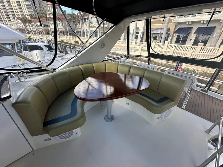 La Vida Loca Yacht Photos Pics Luxurious 2004 Marquis 59 yacht interior with curved seating and wooden table.