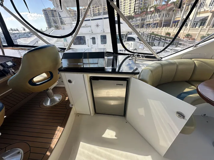 La Vida Loca Yacht Photos Pics Luxurious 2004 Marquis 59 yacht interior with seating, mini fridge, and marina view.