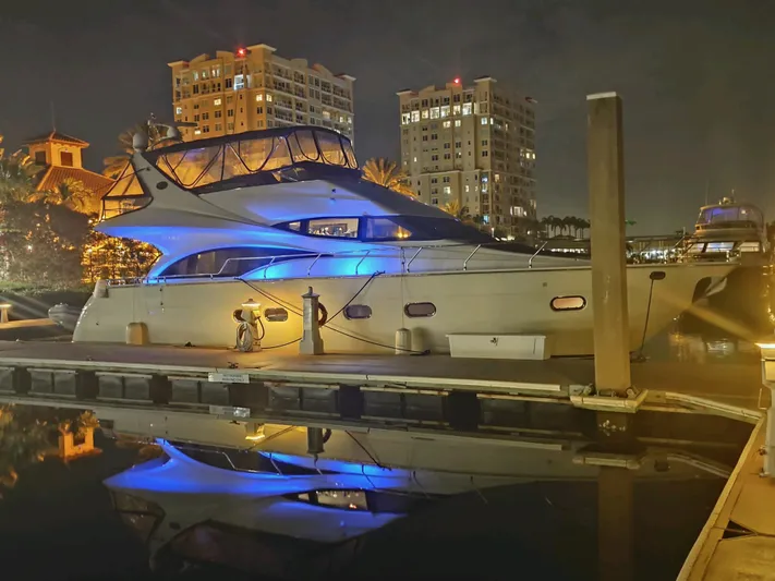 La Vida Loca Yacht Photos Pics Luxurious 2004 Marquis 59 yacht docked at night, illuminated by blue lights.