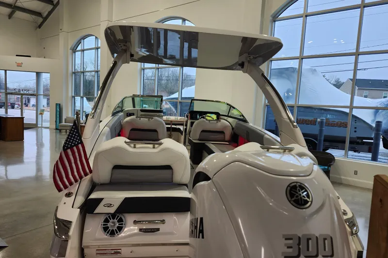  Yacht Photos Pics 2025 Regal LX6 boat with Yamaha engine displayed indoors, featuring American flag.