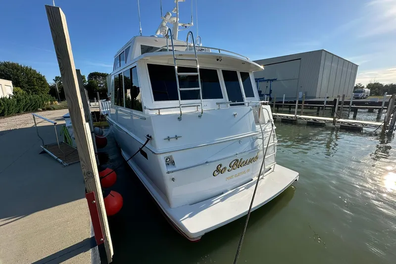 So Blessed Yacht Photos Pics 1998 Viking 54 Motor Yacht docked at marina, rear view with "So Blessed" name.
